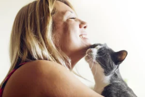 Understanding why cats need taurine. Woman and cat cuddling