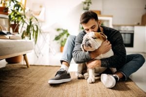 Simplify Pet Care -Young bearded man bonding with his english bulldog