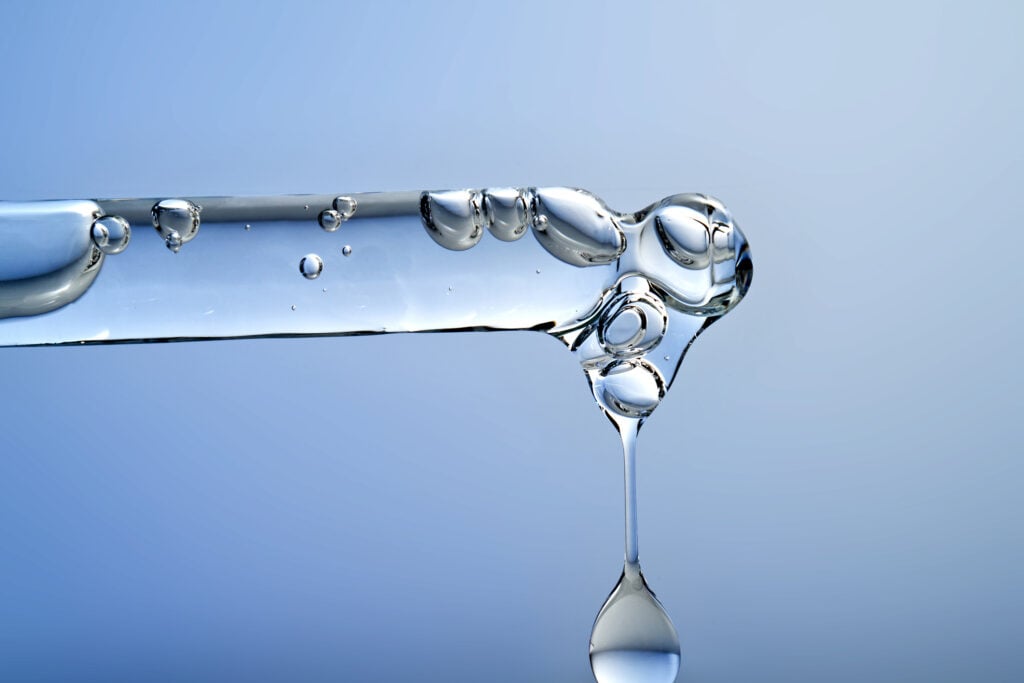 coconut glycerin in dog treats, Pipette dispensing a clear serum droplet with bubbles, symbolizing hyaluronic acid and effective skin hydration barrier repair